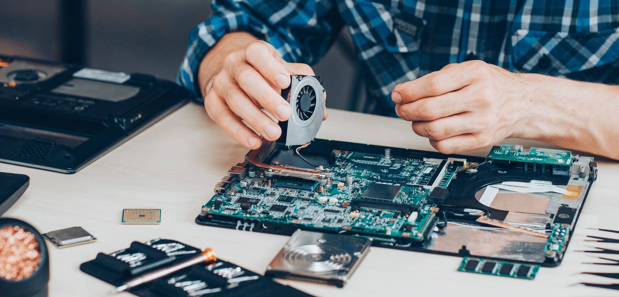Technician repairing a laptop motherboard